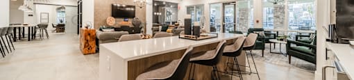 the kitchen and living room of a home with an island and bar stools