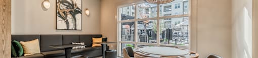 a dining room with a table and chairs and a large window