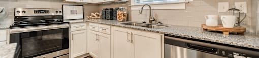 an updated kitchen with stainless steel appliances and granite counter tops