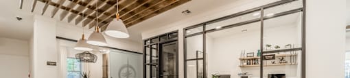 a dining area with a wooden table and chairs and a kitchen with glass doors