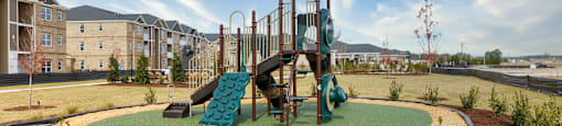 A playground with a green slide and a yellow canopy.