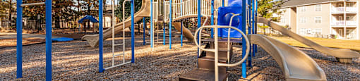 A playground with a slide, swings, and monkey bars.