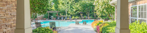 A patio with a pool in the background.