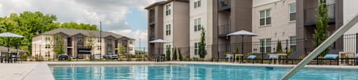 a swimming pool with an apartment building in the background