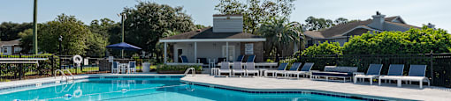 A large swimming pool with a sunny sky in the background.
