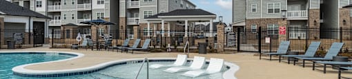 A swimming pool in front of apartment buildings.