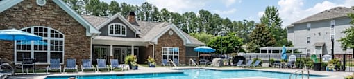 A large outdoor swimming pool with a slide in the middle.