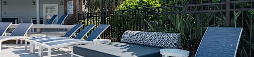 A row of sun loungers are on a patio.
