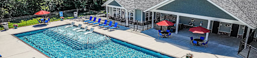 A large outdoor swimming pool surrounded by a covered patio area.