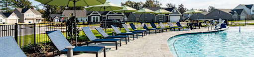 A poolside area with sun loungers and umbrellas.