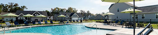 A sunny day at the pool with a yellow umbrella providing shade.