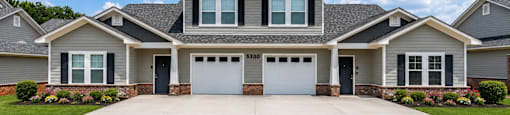 A large house with a grey garage door in front.