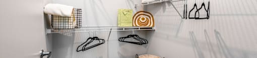 a walk in closet with shoe racks and a trash can