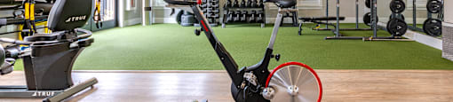 a home gym with exercise equipment and a ceiling fan