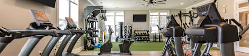 a row of treadmills and televisions in a gym