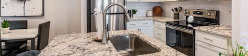 a kitchen with granite counter tops and stainless steel appliances