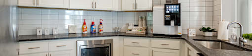 a kitchen with white cabinets and a counter top and a sink
