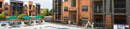 A swimming pool in front of apartment buildings.