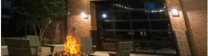 A tall brick chimney is lit up at night.