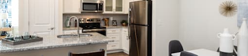 a kitchen and dining room with stainless steel appliances and a granite counter top