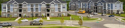 an aerial view of an apartment complex with a parking lot
