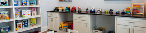a play room with toys and paintings on the wall
