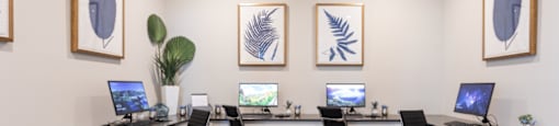 a room with four desks with computer monitors and chairs