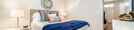 A bedroom with a bed, nightstand, and a ceiling fan.