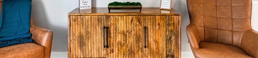 a living room with a cabinet and a painting on the wall