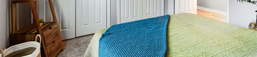a bedroom with two closets and a bed with a blue blanket