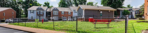 a fenced in park with houses in the background