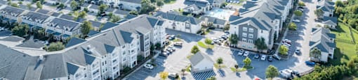 an aerial view of an apartment community with cars parked in a parking lot