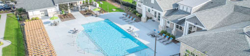 an aerial view of a swimming pool in front of a house