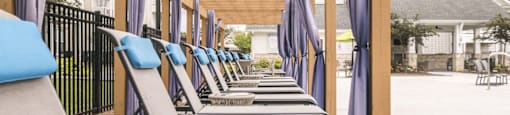 a row of lounge chairs on the porch of a building