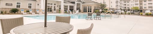 our apartments have a large pool and patio with chairs and tables