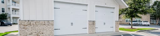 a white church with two garage doors in a parking lot