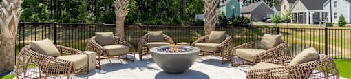 an outdoor patio with chairs and a fire pit