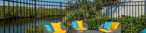 an outdoor patio with wicker chairs and a firepit