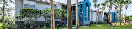 a building with blue pillars and palm trees in front of it