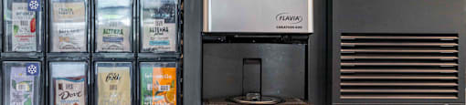 a coffeemaker and a coffee maker on a counter next to a refrigerator