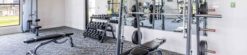a gym with weights and cardio equipment in a building
