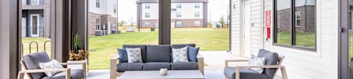 a covered patio with couches and chairs and a coffee table