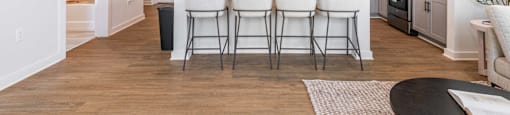 a kitchen and dining room with white chairs and a table