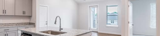 an open kitchen and living room with a sink and counter top