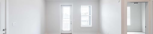 an empty living room with white walls and wood floors