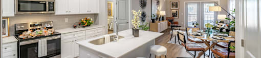 A modern kitchen with white cabinets and stainless steel appliances.