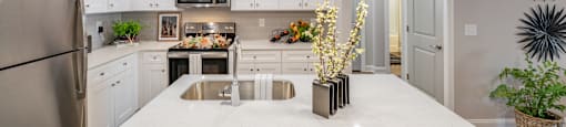 a large kitchen with white cabinets and a white counter top