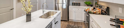 A modern kitchen with white cabinets and stainless steel appliances.