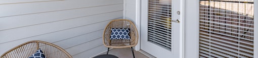 a small porch with two chairs and a door