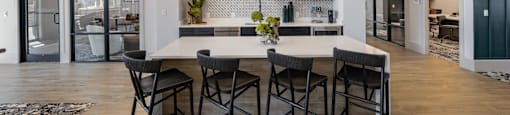 A modern dining room with a white table and chairs.